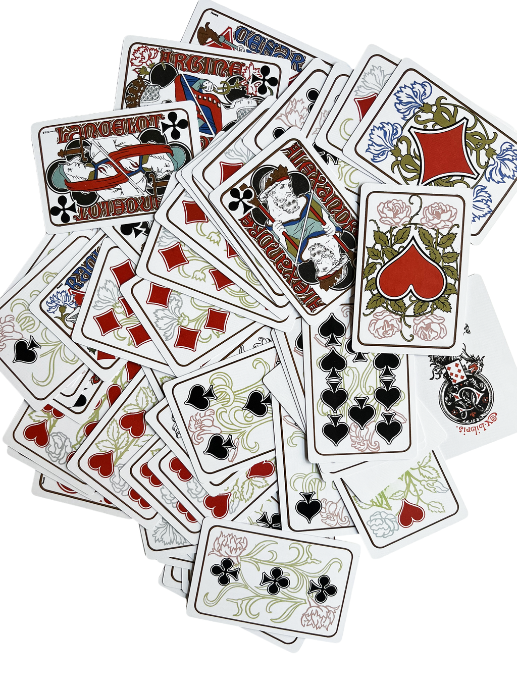 A scattered pile of G. Quenioux Playing Cards - 1900 Paris Exposition Facsimile by Vieux Monde, featuring ornate red, blue, green, and black Art Nouveau designs, evokes Belle Époque Paris on a white background.