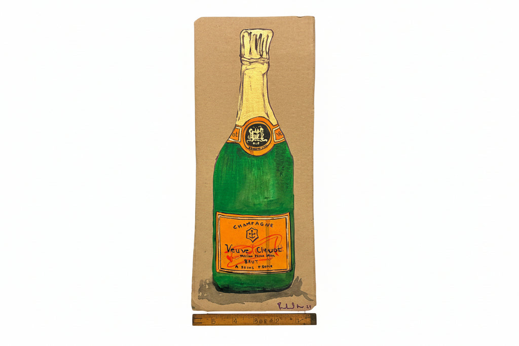 A Rachel Nelson • Champagne print from Thyne Goods featuring a green champagne bottle with gold foil top and orange "Veuve Clicquot" label, drawn on brown paper with a ruler for scale—a distinctive work by Rachel Nelson.