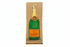 A Rachel Nelson • Champagne print from Thyne Goods featuring a green champagne bottle with gold foil top and orange "Veuve Clicquot" label, drawn on brown paper with a ruler for scale—a distinctive work by Rachel Nelson.