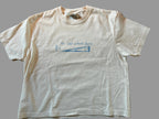 White t-shirt with blue text and graphic on a grey surface