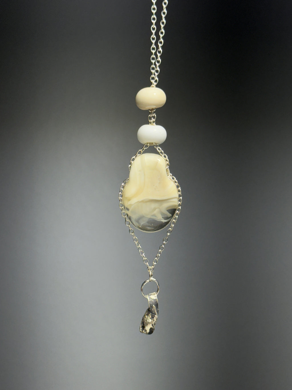 The Dove • Ash Espinoza x Thyne Studio necklace by Thyne Goods features a silver chain with cream and white beads and a marbled beige-gray pendant, crafted from recycled sterling silver, finished with an irregular metallic charm.