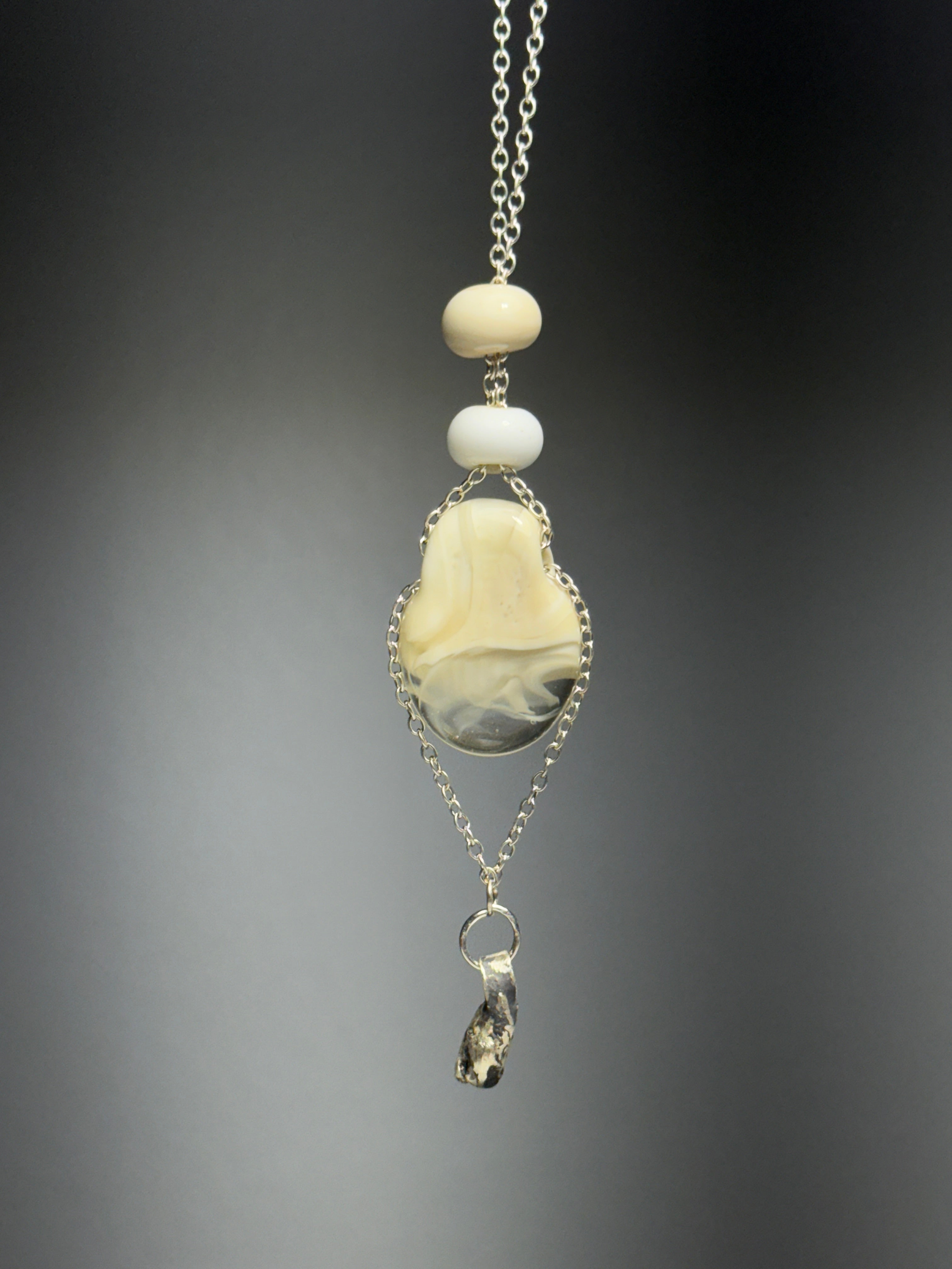 The Dove • Ash Espinoza x Thyne Studio necklace by Thyne Goods features a silver chain with cream and white beads and a marbled beige-gray pendant, crafted from recycled sterling silver, finished with an irregular metallic charm.