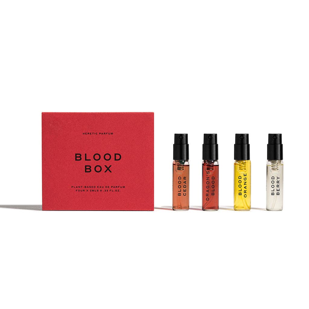 THE BLOOD BOX by Heretic Parfum features a striking red box alongside four blood-inspired scent vials—Blood Cedar, Dragon Blood, Blood Orange, and Blood Berry—creating an immersive fragrance set perfect for collectors.
