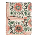 The Botanique Block Print Tablecloth Pink by Indaba Trading is crafted from a linen-cotton blend with a hand block floral print in coral, green, and black on cream, finished with thin coral striped borders and a turned-up corner to show the reverse.