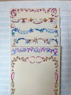 The Parcel French Menu Stationery Set II: 2 includes four creamy white cardstock cards, each with a unique, colorful hand-painted floral border in shades of purple, blue, pink, and brown on lined paper.