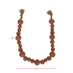 The Clay Garland Terracotta + Jute by Foreside Home & Garden features hand-formed, round terracotta clay beads in various sizes with knotted jute tassels at each end. Largest bead: 1.25", total length: 36.25". Handcrafted in India.