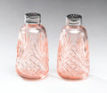 The AA Importing Depression Glass Salt & Pepper Set in Pink features vintage-style shakers with silver lids and a diamond-leaf cut pattern, displayed side by side on a light gray background—ideal for collectors.