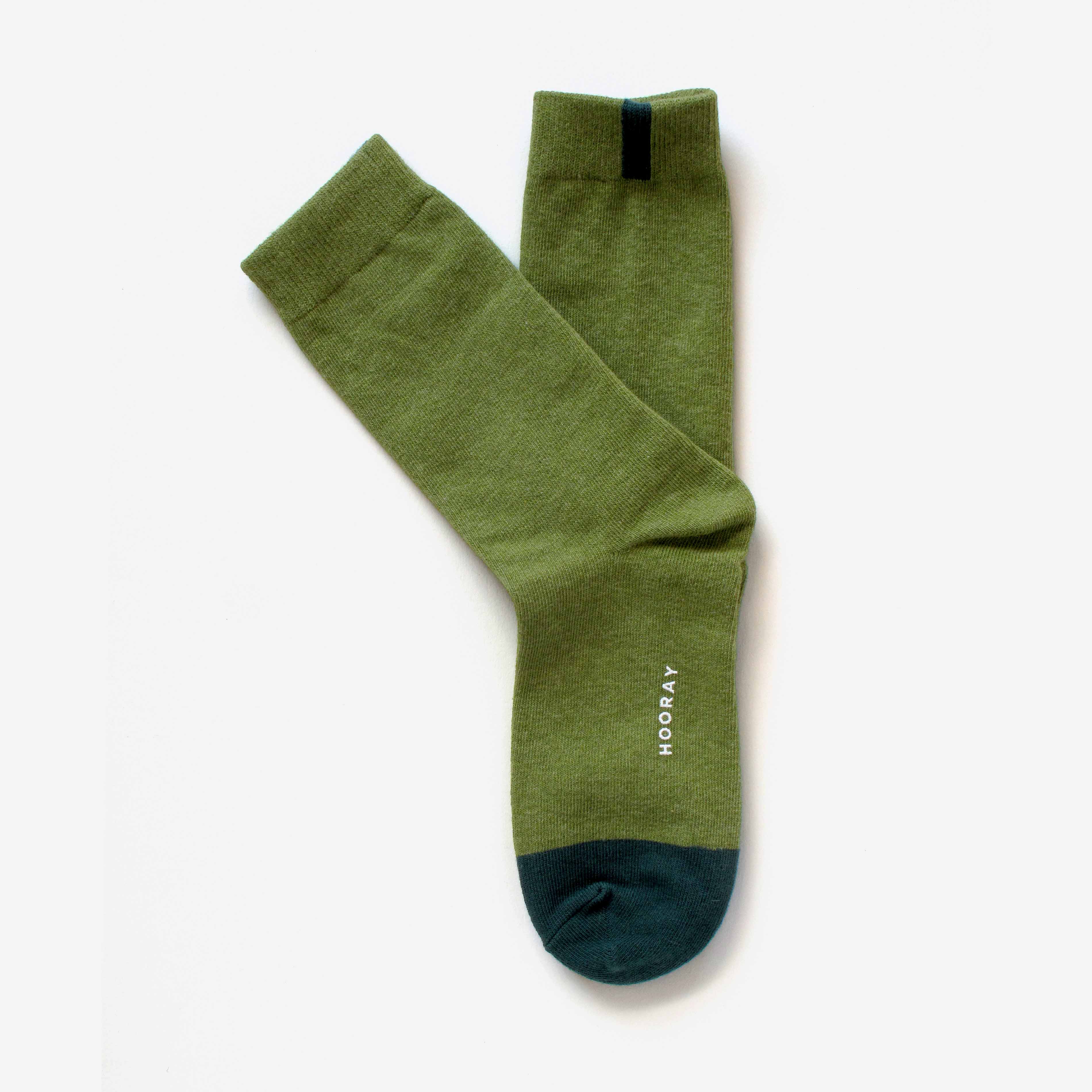 The Lafayette Moss Green Crew Socks by Hooray Sock Co. feature dark green toes, a black top stripe on one unisex sock, and “HOORAY” printed in white on the side. One size.