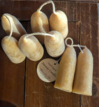 A pair of Yarrow Bone Farmstead's British-style Beeswax Stubby Candles are hand-dipped and arranged on wood. A round tag reads "Hand-Dipped Beeswax Candles," emphasizing their artisanal, handmade charm.