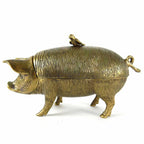 The Pig with Bird Storage Box by Vagabond Vintage features a textured brass pig on four legs, topped with a small bird. Its lid forms the pig’s top half in an antiqued brass finish.
