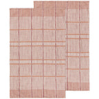 Rectangular rug with pink and white grid lines, inspired by Danica Heirloom’s Bisque Finley Check Dishtowels Set of 2. Features an L-shaped cut-out in one corner that disrupts the classic checked pattern.