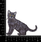 The Black Cat embroidered iron-on patch from Wholesale Applique features a realistic, full-body kitten design. Shown next to a ruler on a white background, the patch measures about 3 inches wide and just over 2 inches tall.
