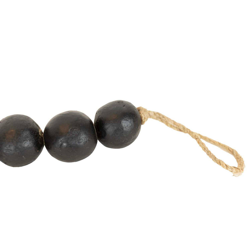 The Black Terracotta Bead + Jute Garland by Foreside Home & Garden features three large round black terracotta beads strung on light brown jute rope with a looped end, displayed on a plain white background.