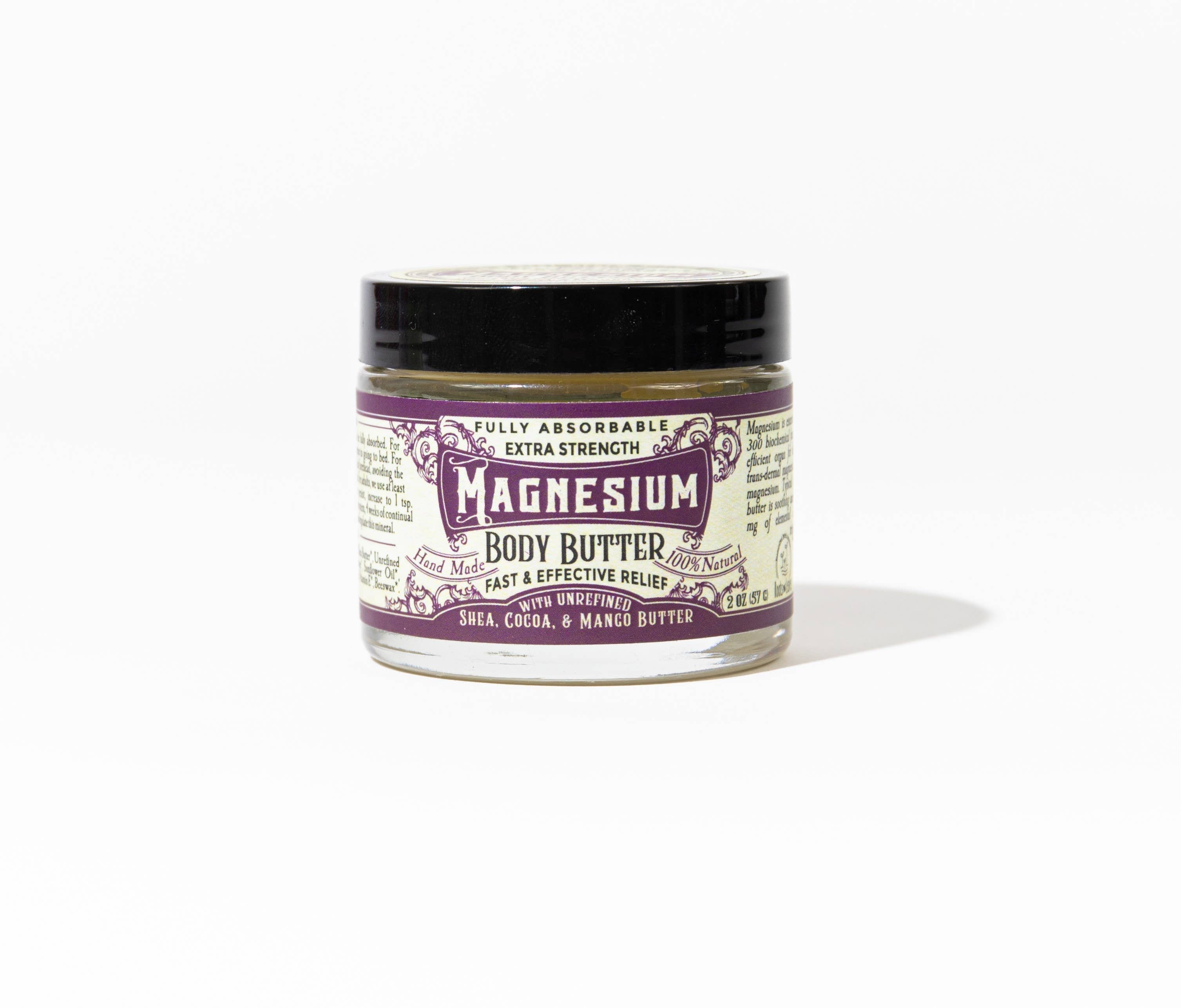 A small glass jar of Roots And Leaves Magnesium Body Butter with a black lid and purple-white label reading "extra strength," featuring shea, cocoa, and mango butter for magnesium absorption, shown on a plain white background.
