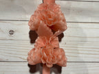 A light pink Rose Quartz Large Oaxaca Marigold Candle made of handmade beeswax, featuring two clusters of molded floral blossoms.