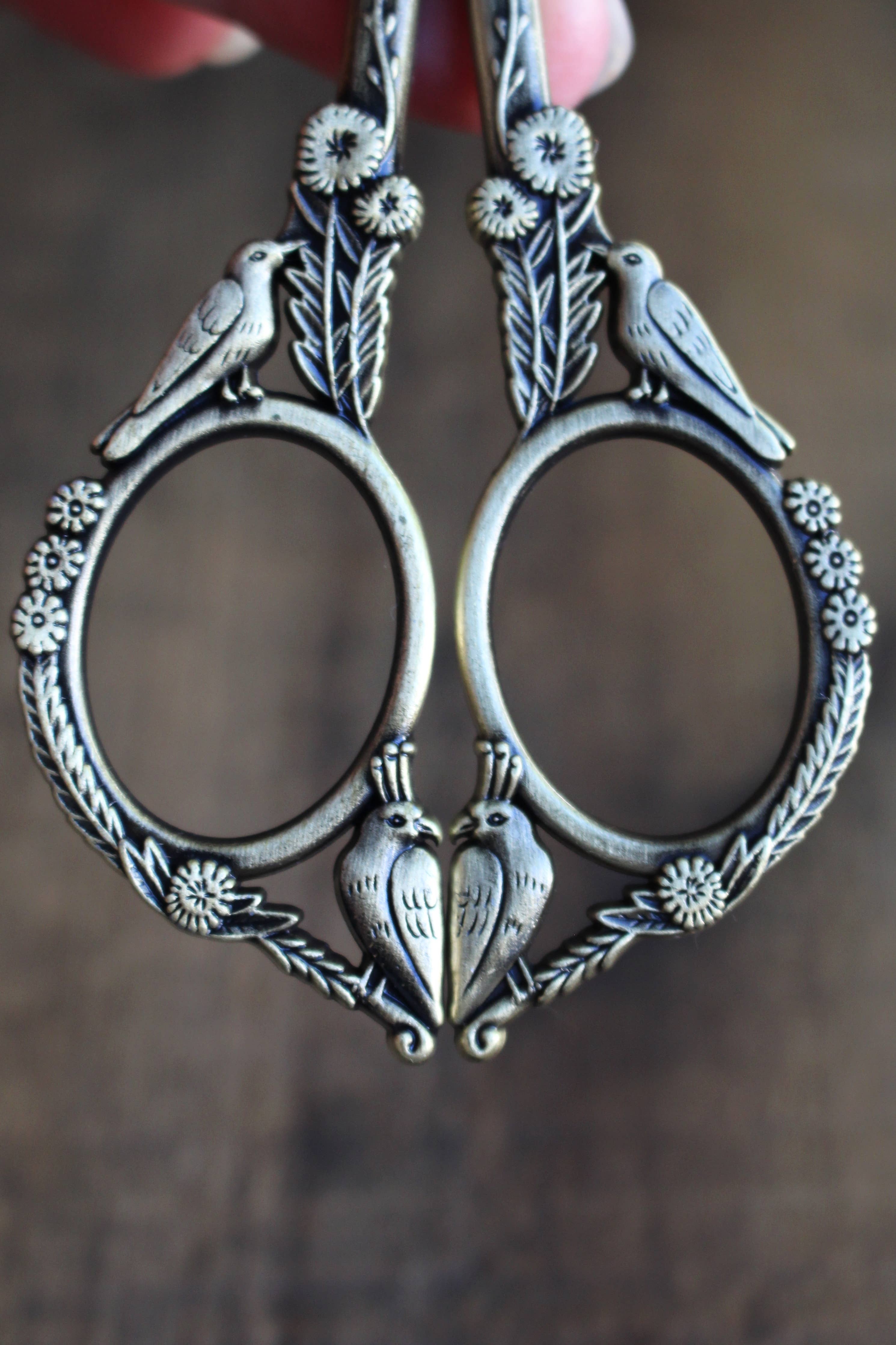 The Feathered Friends Scissors: Antique Gold by NNK Press feature a metal frame with bird handles, adding a charming touch to their design.