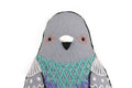 A Kiriki Press Pigeon - Embroidery Kit soft toy with a gray head, orange markings near the eyes, and intricate turquoise and purple stitching on its chest.