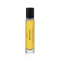 A clear glass bottle of Heretic Parfum SMUDGE: 15ML with yellow liquid and a black cap features minimalist design, suggesting notes of juniper and frankincense, displayed on a white background.