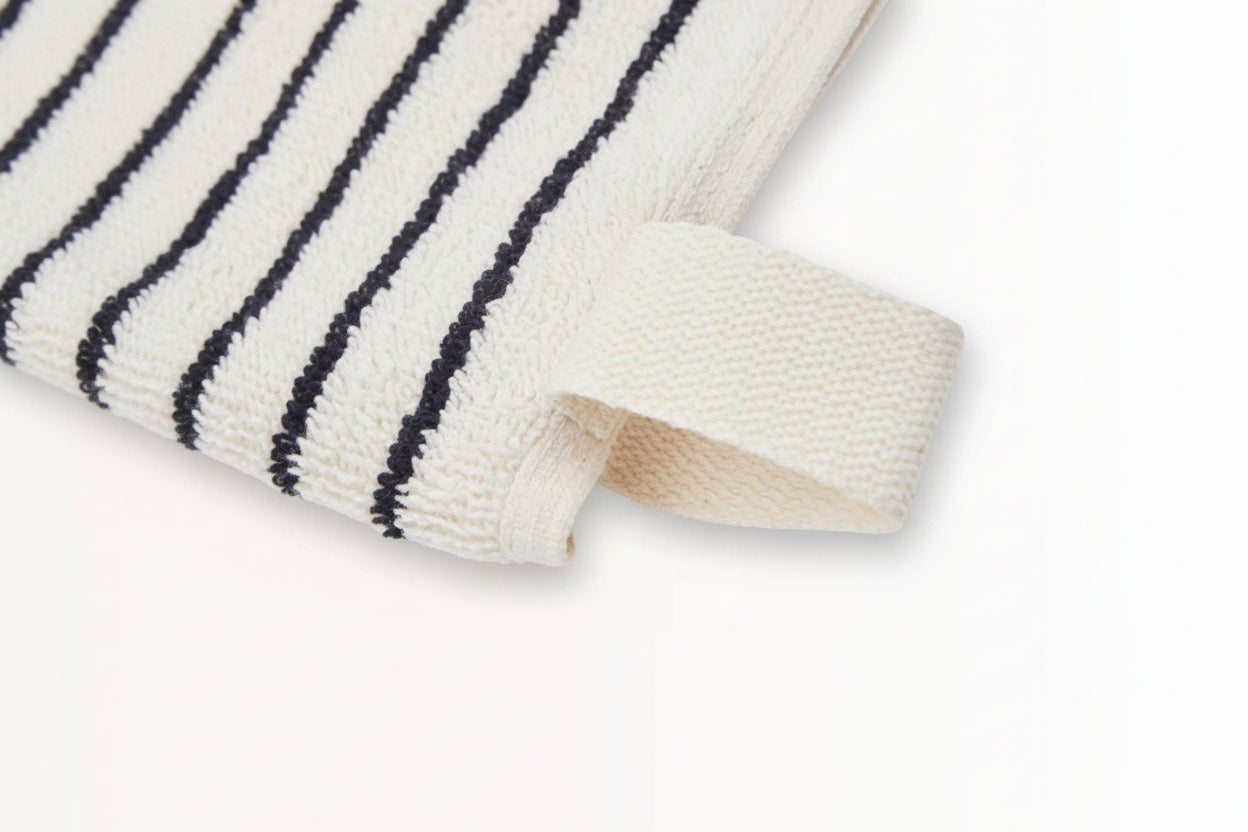 Close-up of The Loomia Turkish Cotton Striped Terry Hand Towel in cream with black stripes and a corner loop, shown on a white background—perfect for those seeking highly absorbent towels.