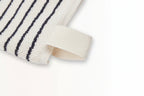 Close-up of The Loomia’s Turkish Cotton Striped Terry Towel: Bath Sheet featuring quick-drying Turkish cotton, black horizontal stripes, and a corner fabric loop, displayed on a plain white surface.