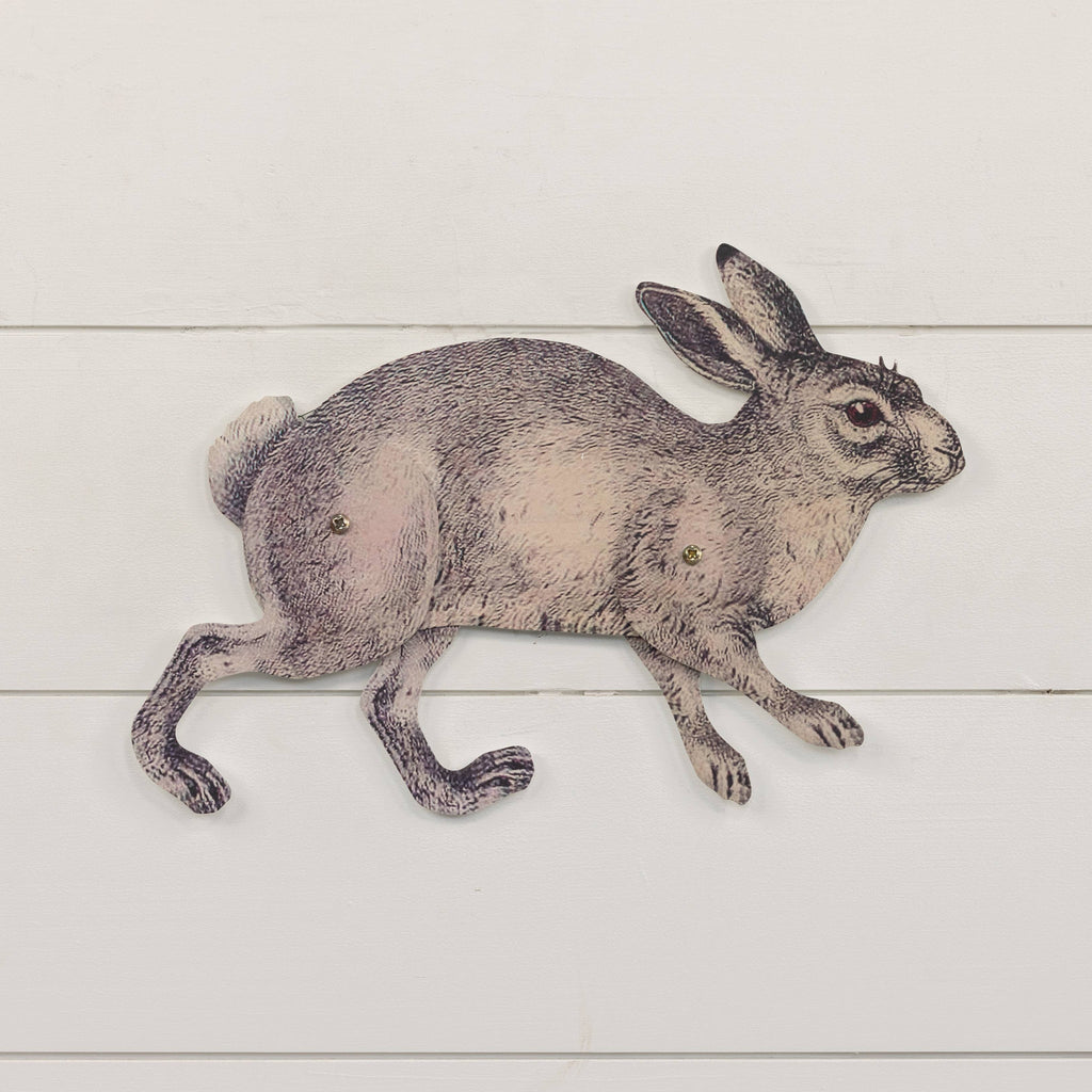 The Ragon House POSEABLE METAL BUNNY features a vintage-style rabbit in mid-run, detailed with visible joints for movable parts, mounted on a white wooden panel with half-circle hangers.