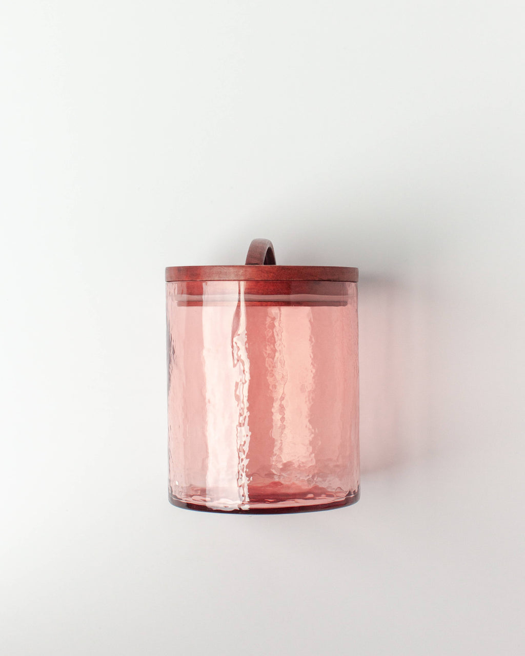The Handblown Hammered Glass Canisters: Blush / Small by Creative Women features translucent pink recycled glass with a textured surface and a hand-carved wooden lid on a plain white background.