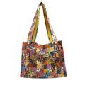 The Calico Quilted Tote by Handker Bandanas features a geometric pinwheel quilt pattern in bright colors, two shoulder straps, and a small kinder label on the front against a plain white background.