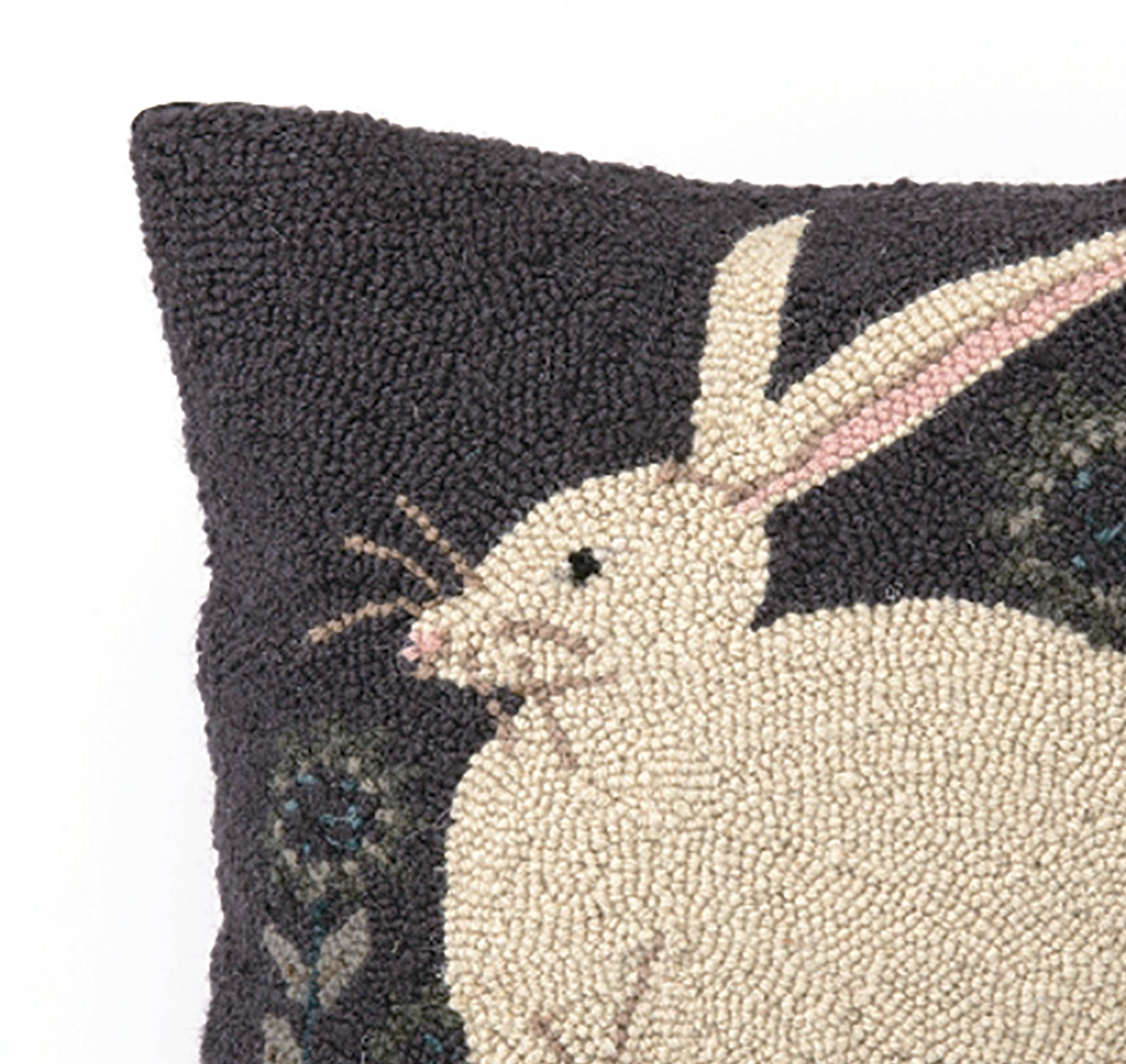 The Hare with Sunflowers Hook Pillow by Warren Kimble for Peking Handicraft features a hooked wool design of a white rabbit with pink in its ear on a dark background with green, showing only half the pillow and rabbit.