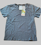 A Thyne Goods Ojai Tee in Diesel Grey, made from a hemp cotton blend with short sleeves, is laid flat on a gray background. Tags are attached near the collar, one displaying the text FEAR LOVE.
